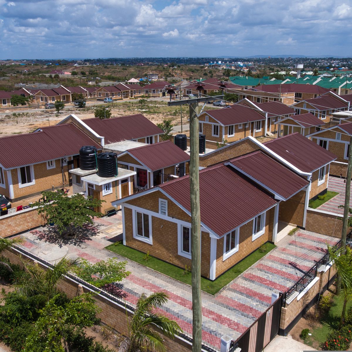 Completed housing units with landscaping, boundary walls and paved driveways